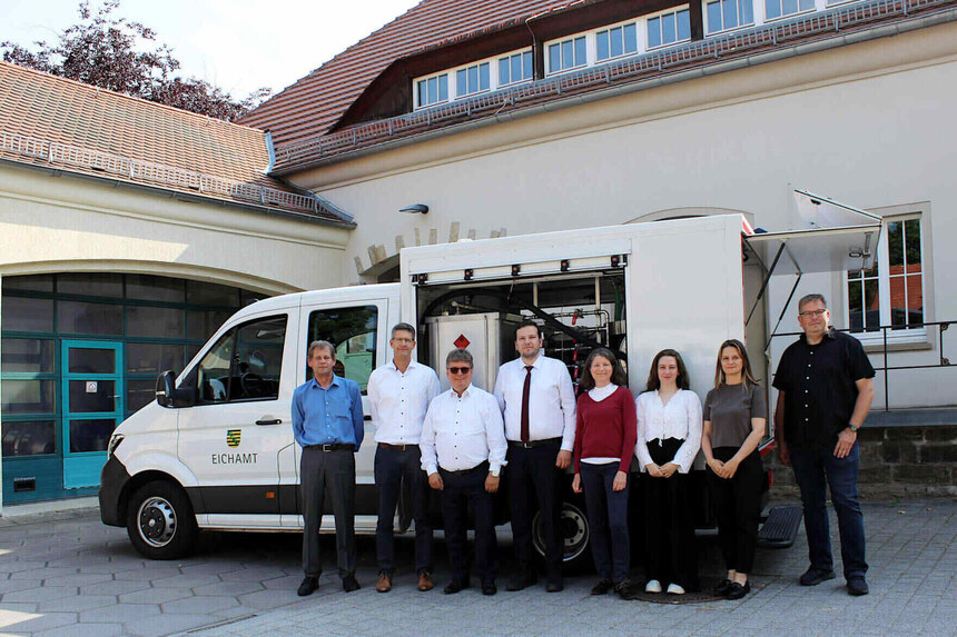 Gruppe von acht Personen, die vor einem prüffahrzeug des Eichamtes Dresden stehen.