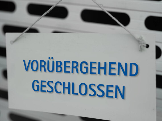 Weißes Schild, das an einem Tor hängt. Darauf steht: "Vorübergehend geschlossen"
