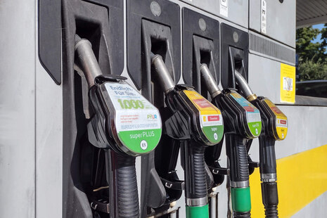 Vier Zapfpistolen an der Zapfsäule für SuperPlus, Super, Super E10 und Diesel nebeneinander. Oberhalb von jedem Zapfpunkt klebt ein graues Kennzeichen „geeicht bis 2023“.